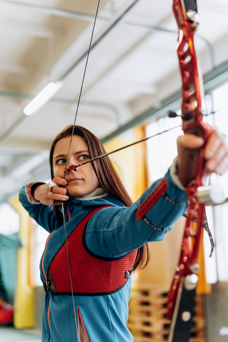 Woman in Blue Top Holding a Bow